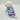 Dog wearing a light blue hoodie with pink heart patterns on a white background