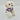 Small white dog wearing a purple outfit with a cartoon design on a light gray background