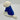White dog wearing a blue coat on a light gray background