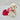 White fluffy dog toy with a pink dress on a light gray background